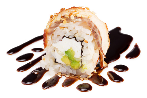 Sushi roll (California) with cream cheese, avocado and smoked eel, unagi sauce on white background. Japanese food