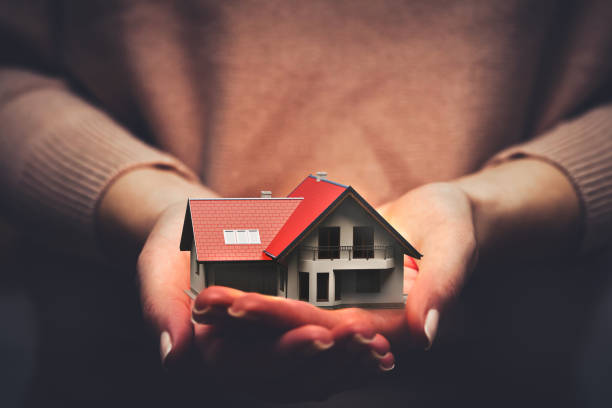 istock Home insurance, a house model safe in hands 1264163602