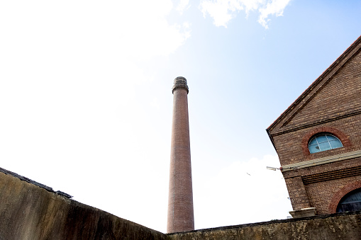 Industrial exterior of abandoned factory with smoke stack, sky  background with copy space, full frame horizontal composition