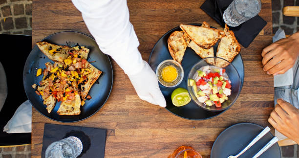 istock Top Down Shot of Gloved Waiter Placing Ceviche on Table 1264167828