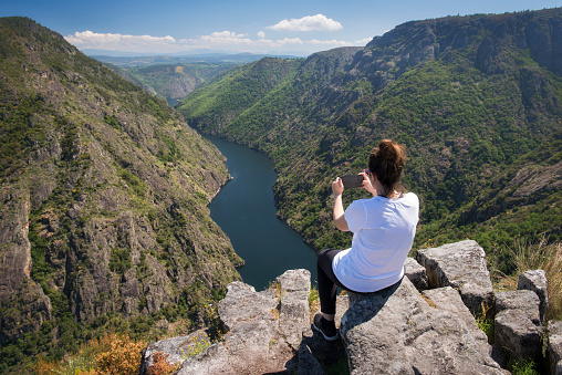 Woman taking pictures in a beautiful viewpoint in the Sil Canyon. Ribeira Sacra, Galicia