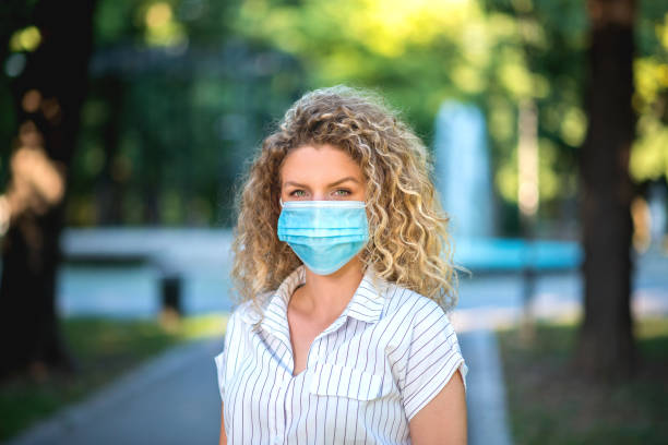 istock Woman smiling behind the protective face mask 1264171490