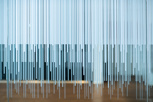 Glass wall with opaque stripes showing the wood floor of the conference room.
