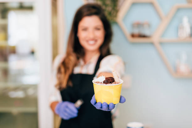 istock Happy brunette worker in ice cream store 1264176995