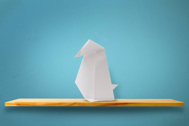 istock Blank origami penguin on a wooden shelf 1264180032