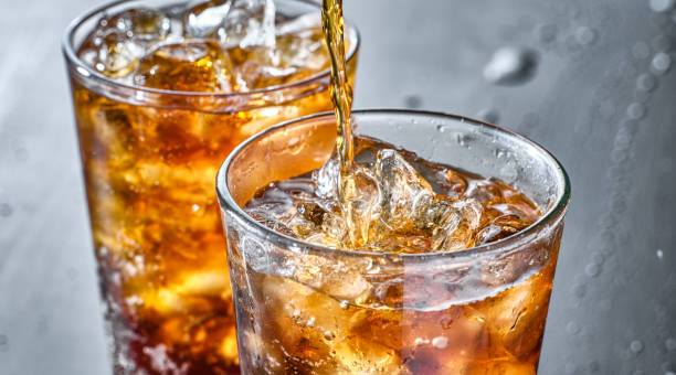 istock two cups of cola soft drink being poured into glass 1264183472