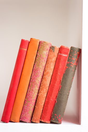 Group Antique Red and Orange Books Leaning