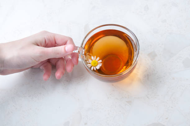 istock Hand holding a Cup of chamomile tea on the table 1264194208
