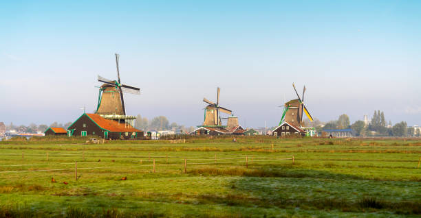 amsterdam netherlands zaanse schans, home of dutch pastoral delight is dotted with winsome windmills and little green wooden house - zaanse schans bridge house water imagens e fotografias de stock