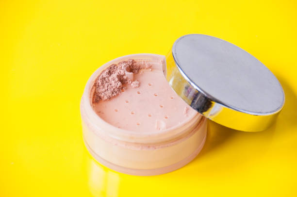 istock Open jar with loose powder on a yellow background 1264204516