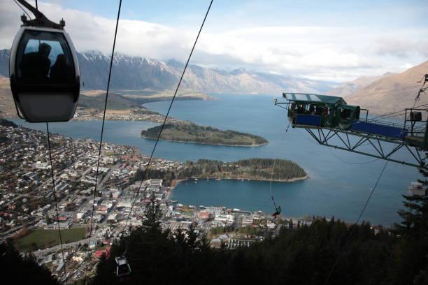 Aerial view of Queenstown and Lake Wakatipu with Bungee Jumping in Queenstown  New Zealand Aerial view of Cable Car above Queenstown and Lake Wakatipu with Bungee Jumping and the Remarkables mountain range in Queenstown  New Zealand overhead cable car photos stock pictures, royalty-free photos & images