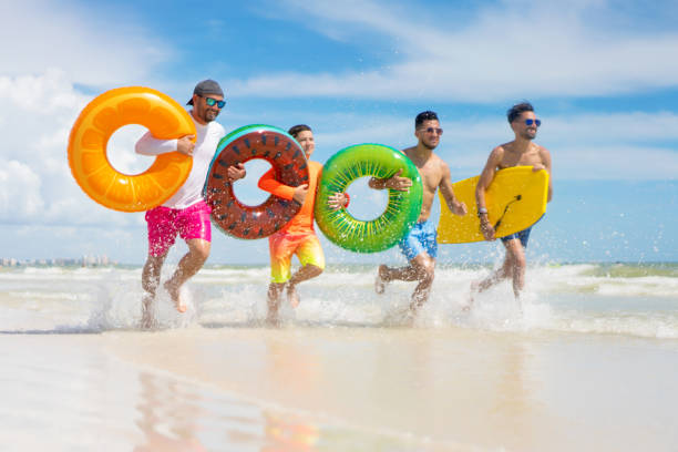 istock Running with inflatable ring tubes on a beach in Miami 1264206954