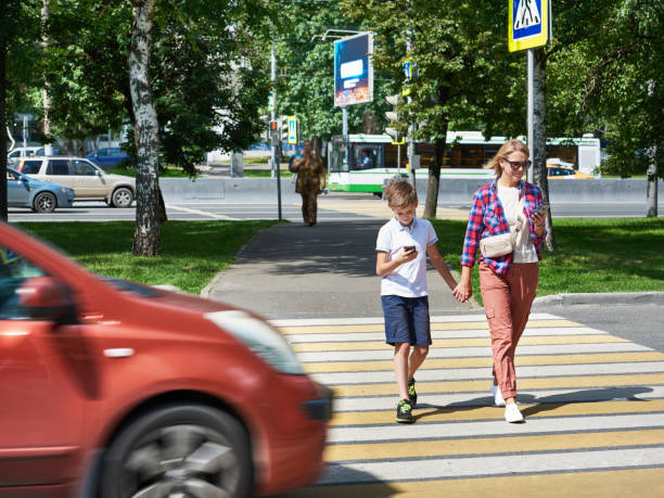 gevaar voor het gebruik van smartphone door voetgangers op de weg - voetgangersstoplicht stockfoto's en -beelden