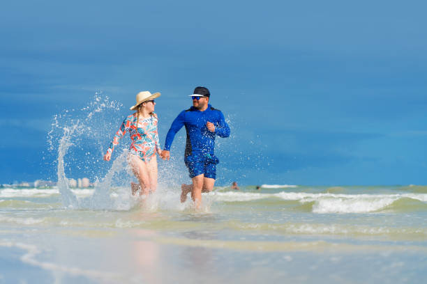 istock Young couple running on the beach 1264215480