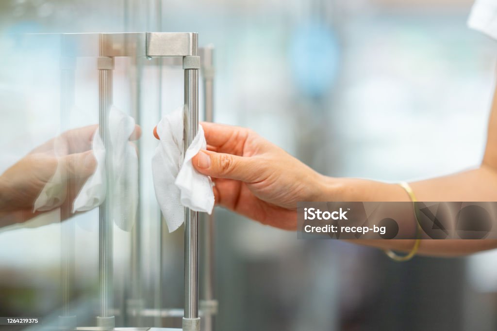 Foto de close-up da mão da mulher ao desinfetar maçaneta de geladeira em supermercado antes de abrir porta - Foto de stock de Lenço umedecido royalty-free