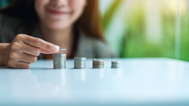 istock Businesswoman holding and stacking coins 1264223418