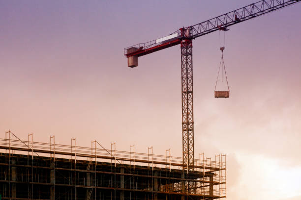 istock Concrete and brick building construction site with crane at dusk. 1264224286