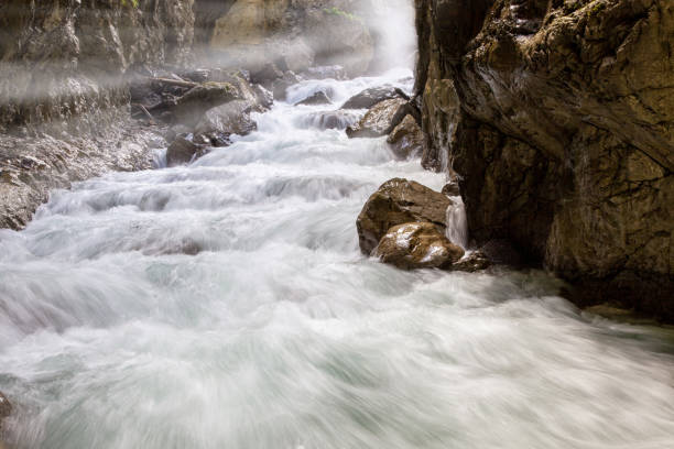 l’eau qui coule sur les rochers avec des rayons du soleil. vue scénique de l’eau fluide dans la gorge de partnach - bavaria wetterstein mountains nature european alps photos et images de collection