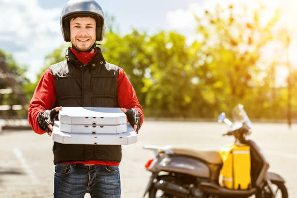 istock Cheerful Courier Holding Pizza Boxes Smiling To Camera Standing Outdoors 1264225520