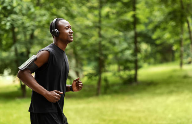 vue latérale de la formation africaine de joggeur d’homme au stationnement - black forest audio photos et images de collection