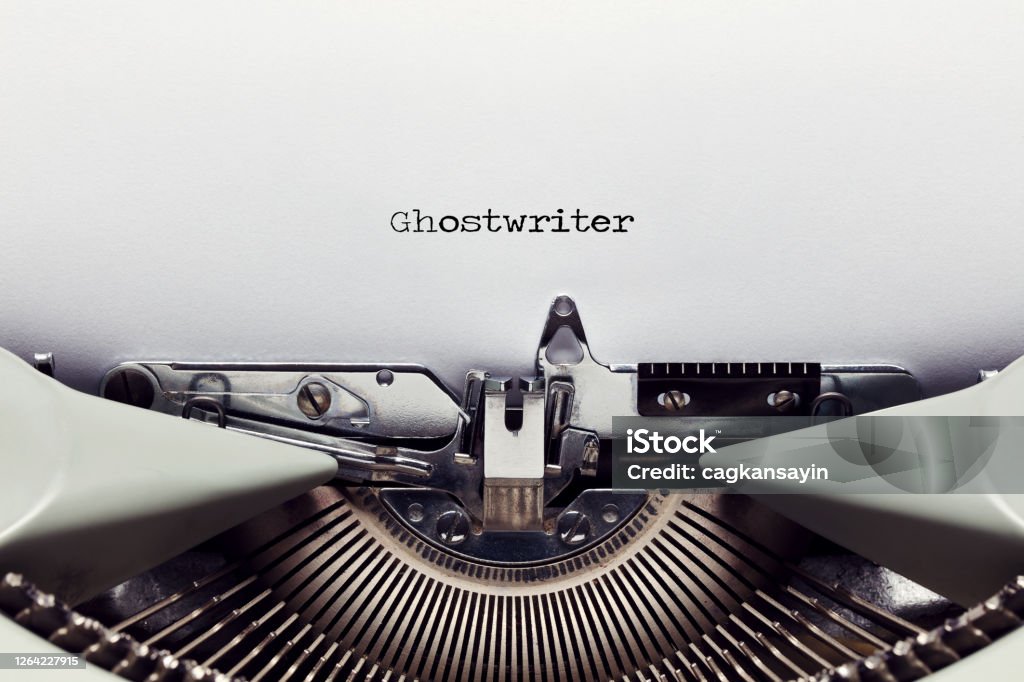 The word ghost writer typed on the paper with a vintage typewriter The word ghostwriter typed on the paper with a vintage typewriter. Close up flat lay view Biography Stock Photo