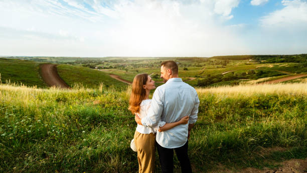 istock Young couple enjoying landscape outdoors, back view 1264229592