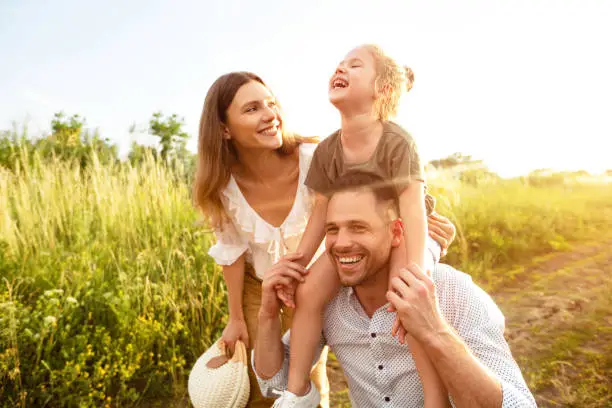 Photo of Happy parents and kid walking together in summer