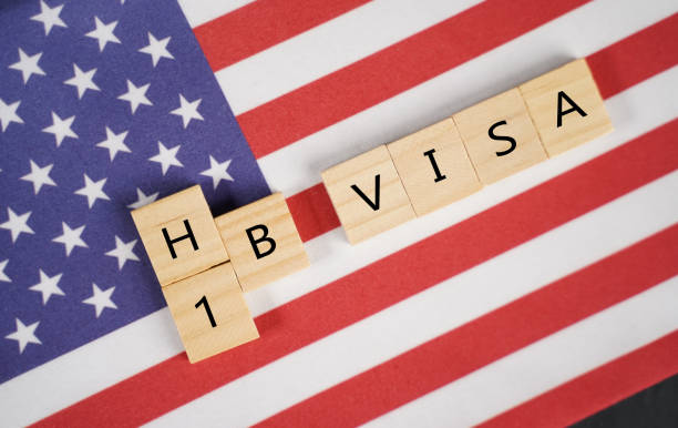Concept of H1b Visa for foreign workers showing wooden letters with US or United states flag as background. Concept of H1b Visa for foreign workers showing wooden letters with US or United states flag as background emigration and immigration stock pictures, royalty-free photos & images