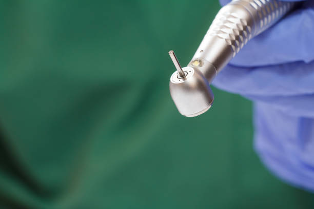 istock Dentist's hand in glove with dental handpiece. 1264231520