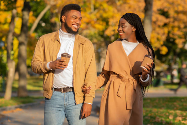 istock Romantic black couple with coffee walking outdoors in autumn park 1264232925