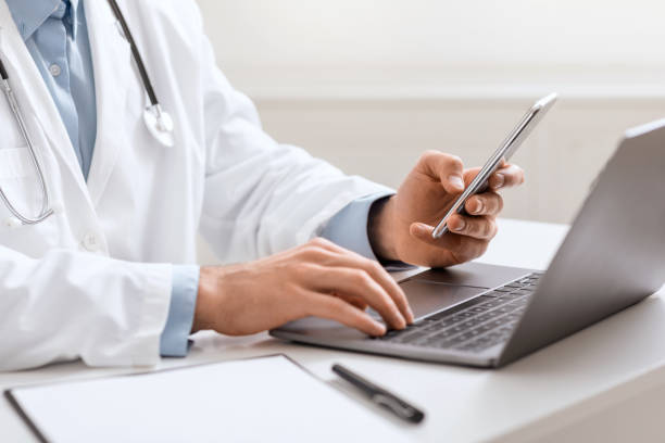 istock Doctor working with smartphone and laptop , close up 1264233177