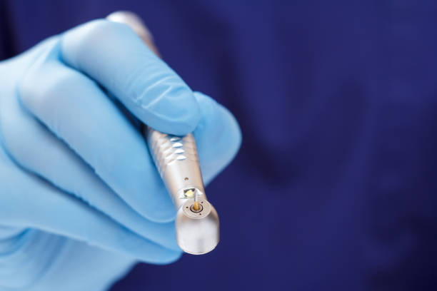istock Dentist's hand in glove with dental handpiece. 1264238666