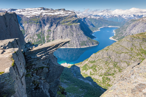 Trolltunga, Odda, Norway; July 16, 2020 - Young adult admiring the view from Trolltunga.