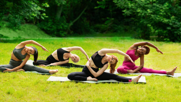 istock Yoga for inner harmony. Multinational women on their morning practice at park 1264240643