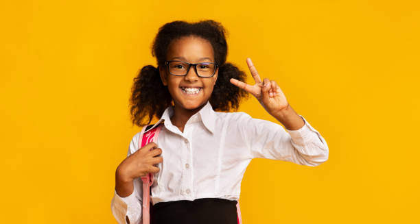istock Cheerful Elementary School Girl Gesturing V-Sign Standing, Panorama, Studio Shot 1264244998