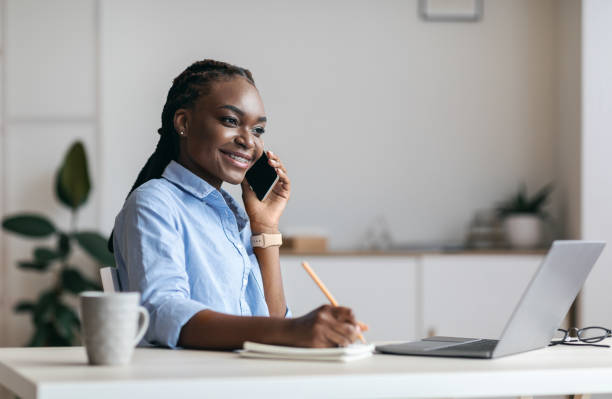 istock Millennial Black Woman Manager Taking Notes And Talking On Cellphone In Office 1264247222