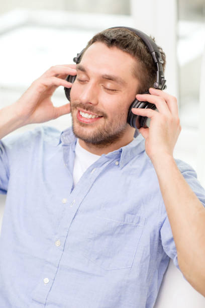 istock smiling young man in headphones at home 1264248950
