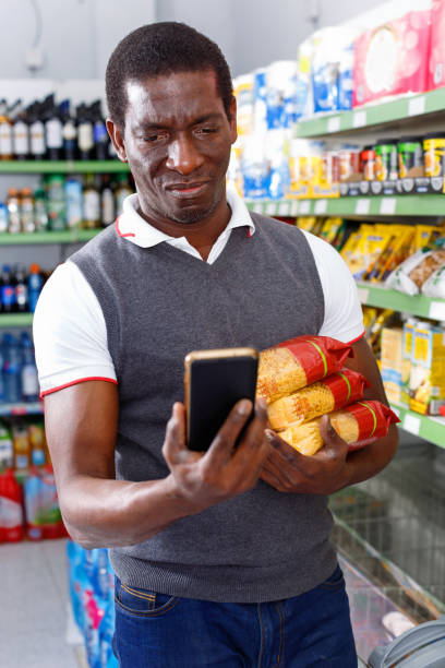 istock Positive  afro man using his smartphone while shopping in supermarket 1264253959