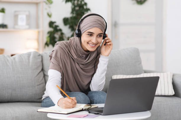 istock Online Education. Smiling Arabic Gir Watching Webinar On Laptop At Home 1264254767