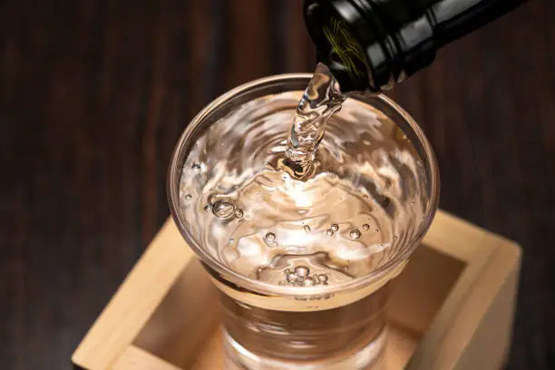Sake overflows from the square cup