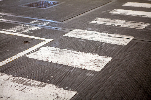 White zebra crossing marks on the concrete floor of a car park