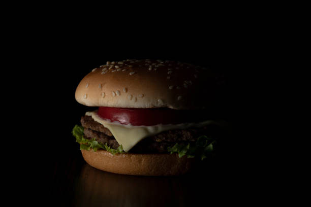 Junk food image. Hamburger on dark background.