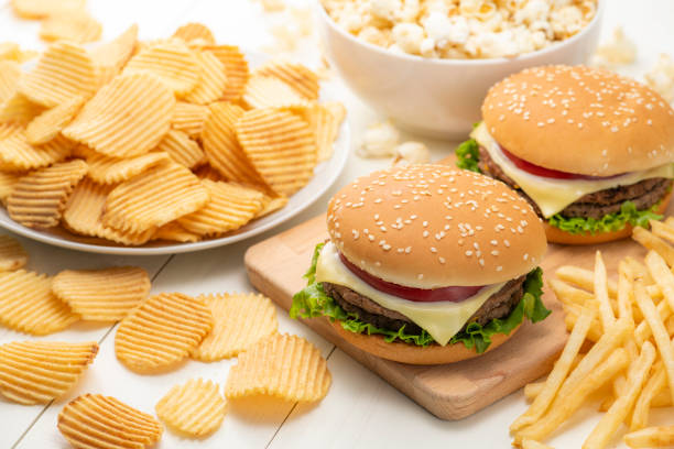 junk-food-bild. hamburger mit pommes frites, kartoffelchips und popcorn. - trans fats stock-fotos und bilder