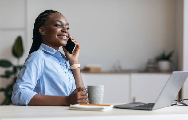 istock Relax At Work. Happy Black Secretary Talking On Cellphone And Drinking Coffee 1264267382
