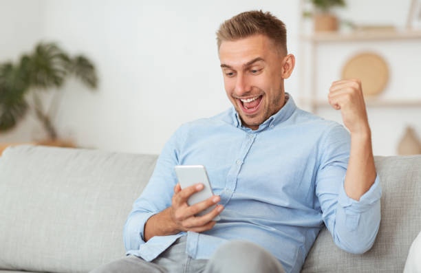 istock Excited male employee feeling ecstatic holding phone 1264269586