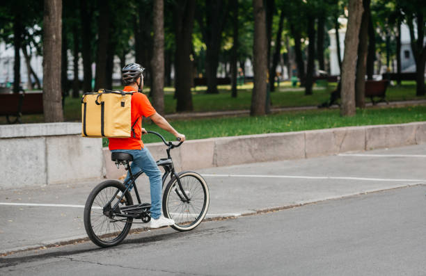 istock City delivery. Courier in helmet with big backpack rides on bicycle 1264269630