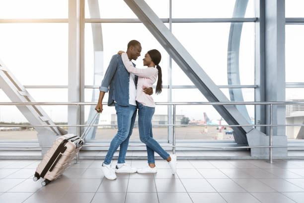 신혼 여행 준비. 공항 터미�널에서 포옹하는 낭만적 인 아프리카 커플 - honeymoon airplane window travel 뉴스 사진 이미지