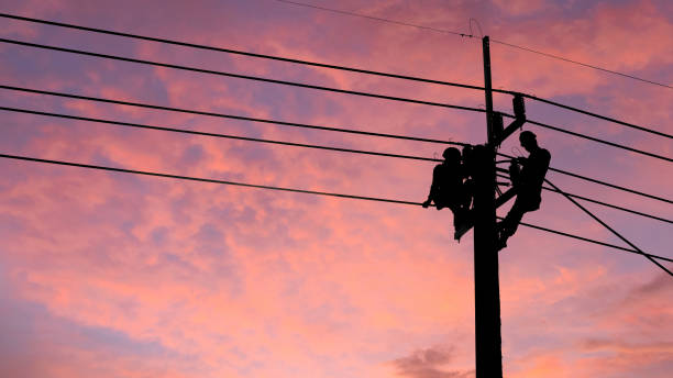 elektriker-arbeiter klettern strommast, um die beschädigten stromkabelleitung probleme nach dem sturm zu reparieren. stromleitungsunterstützung, technologiewartung und entwicklungsindustriekonzept - stromleitung stock-fotos und bilder