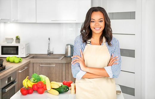 Young african woman cooking in kitchen. Cooking at home. Healthy food. Dieting concept.