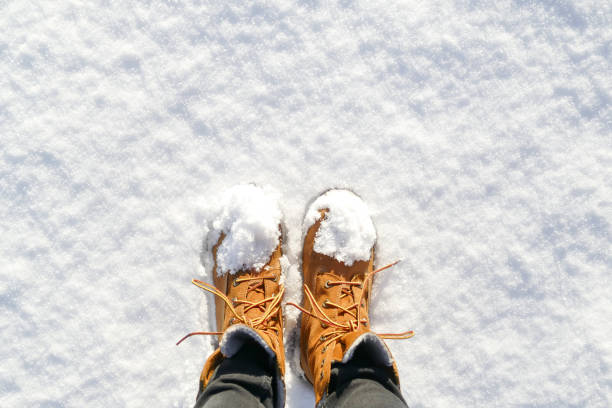 vista superior de zapatos / botas en nieve fresca. - bota de la nieve fotografías e imágenes de stock